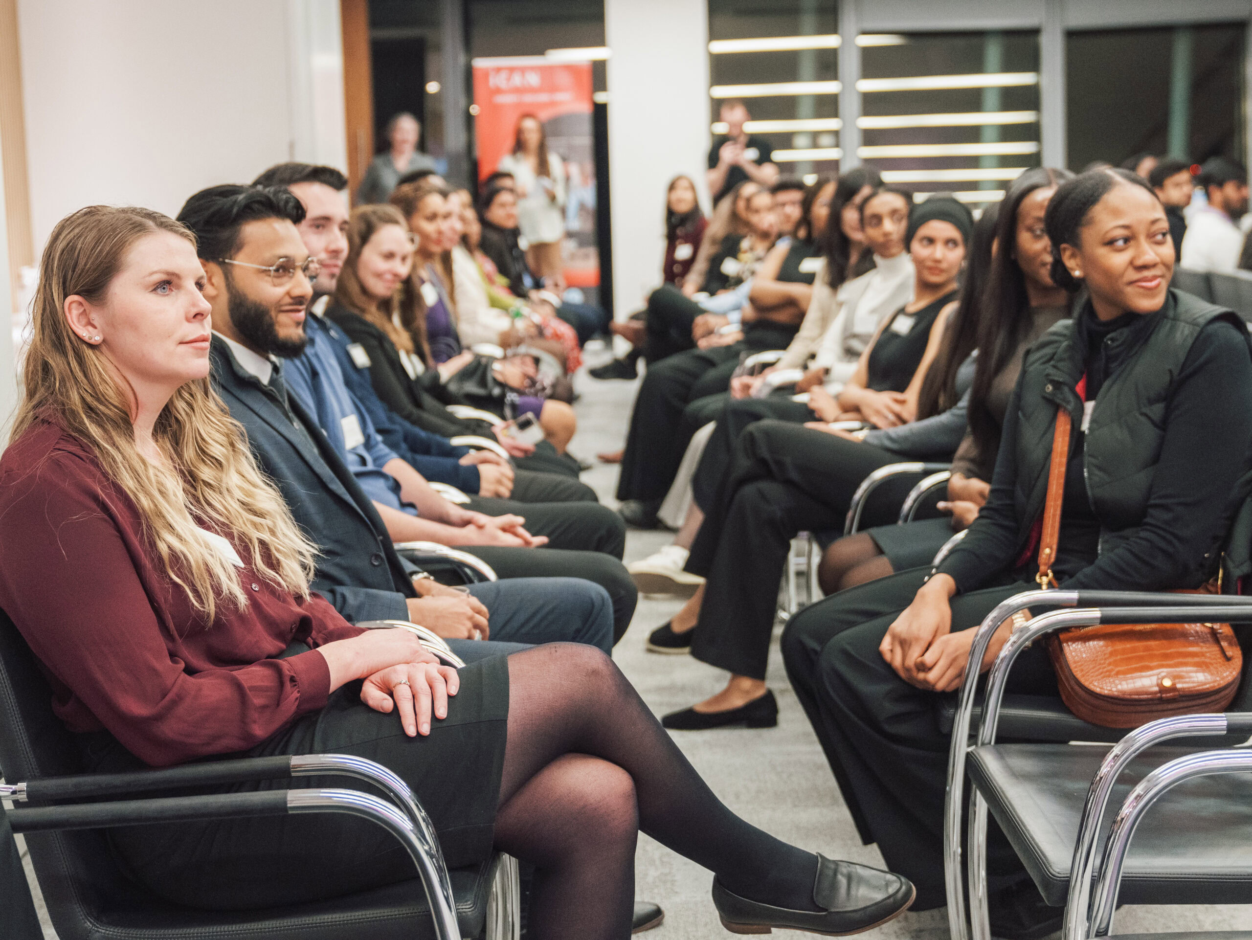 A diverse group of individuals seated in a conference room during a professional event.
